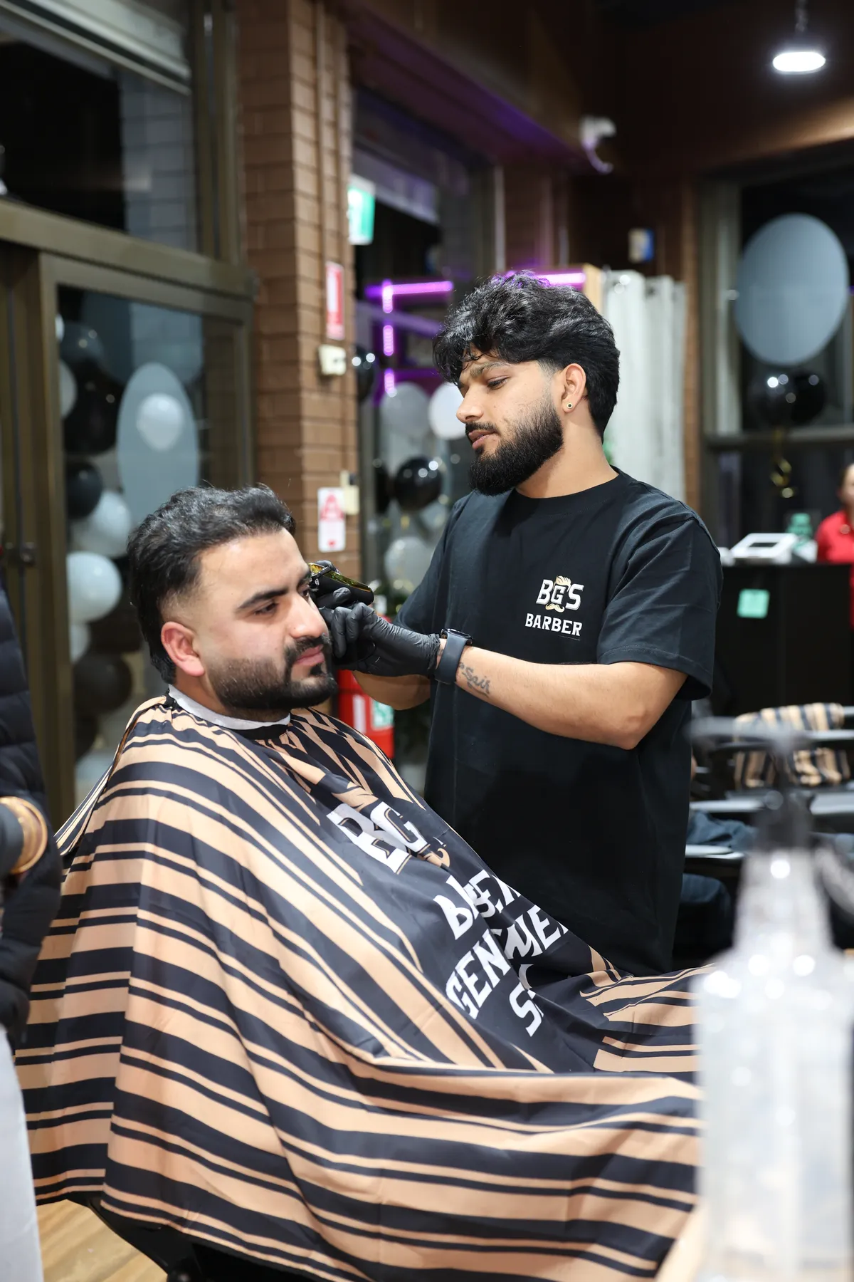 A BGS barber shaping a fade with clippers