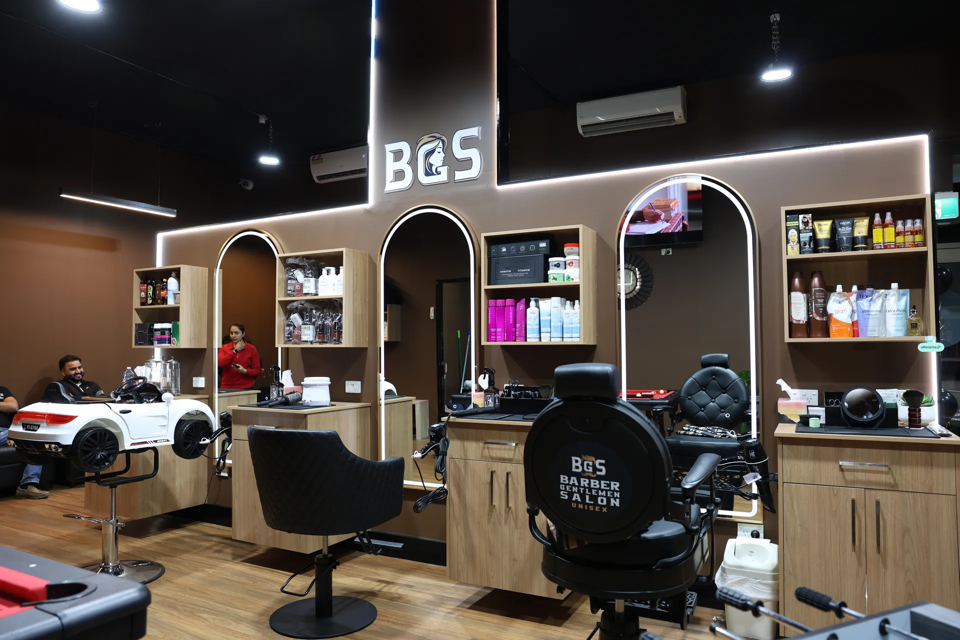 The BGS salon floor with lit arched mirrors and timber stations