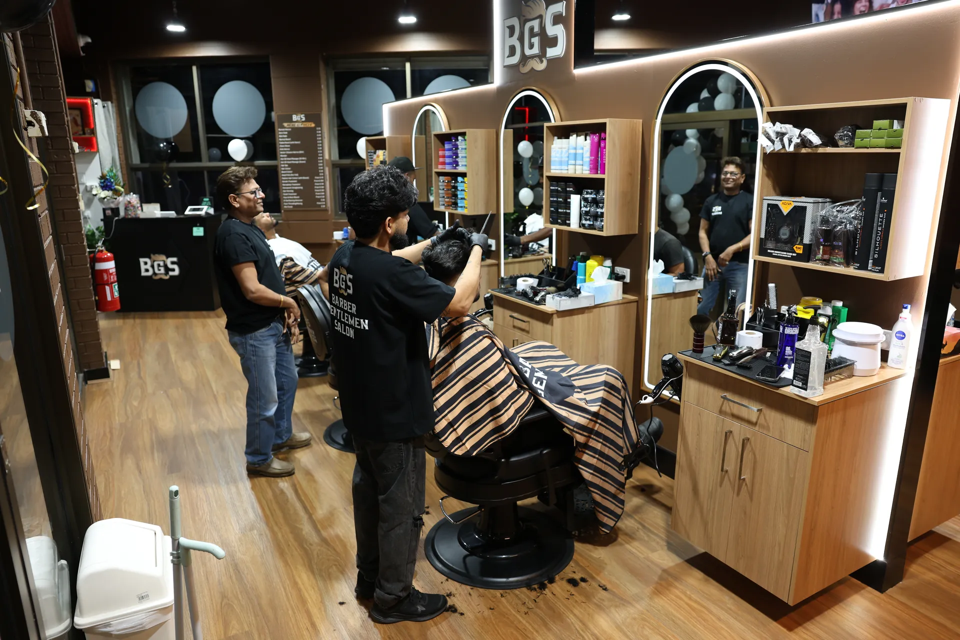 An artist cutting a client's hair on the open salon floor