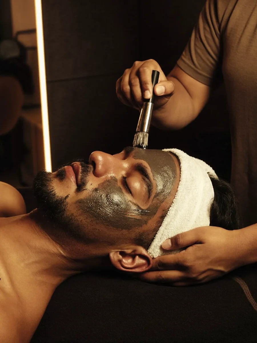 An Indian man relaxing through a charcoal facial treatment