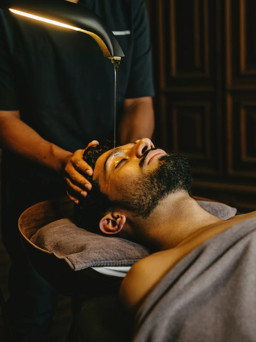 An Indian man receiving a warm hot-oil head massage