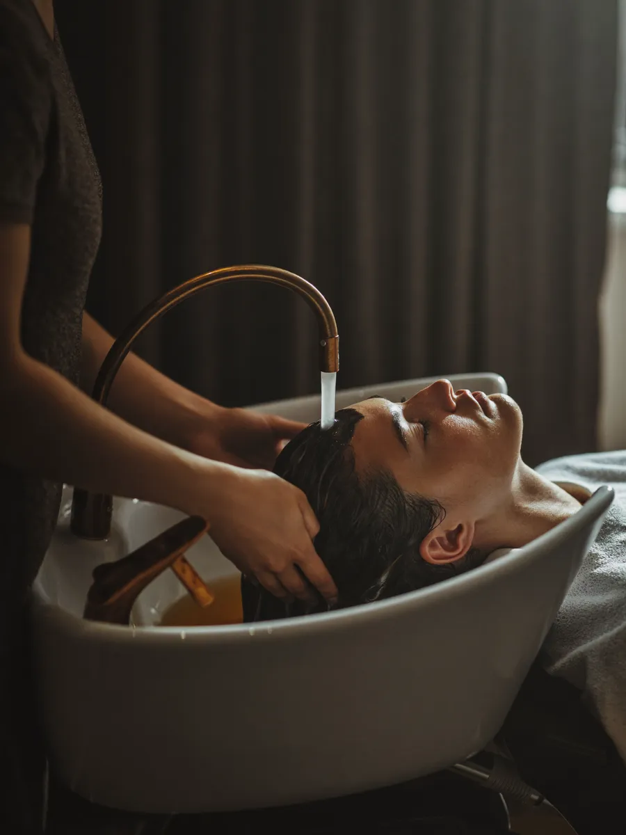 A client relaxing through a warm hair-spa rinse